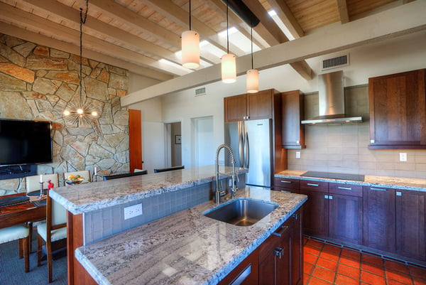 Restaurant style kitchen remodel ceramic tile flooring and a two tiered kitchen island. Ceiling has exposed rafters and a skylight