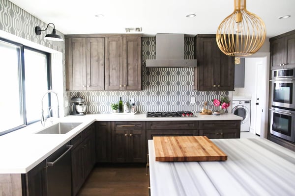 Beautifully textured and patterned kitchen remodel with a textured tile backsplash and a marbled kitchen island countertop