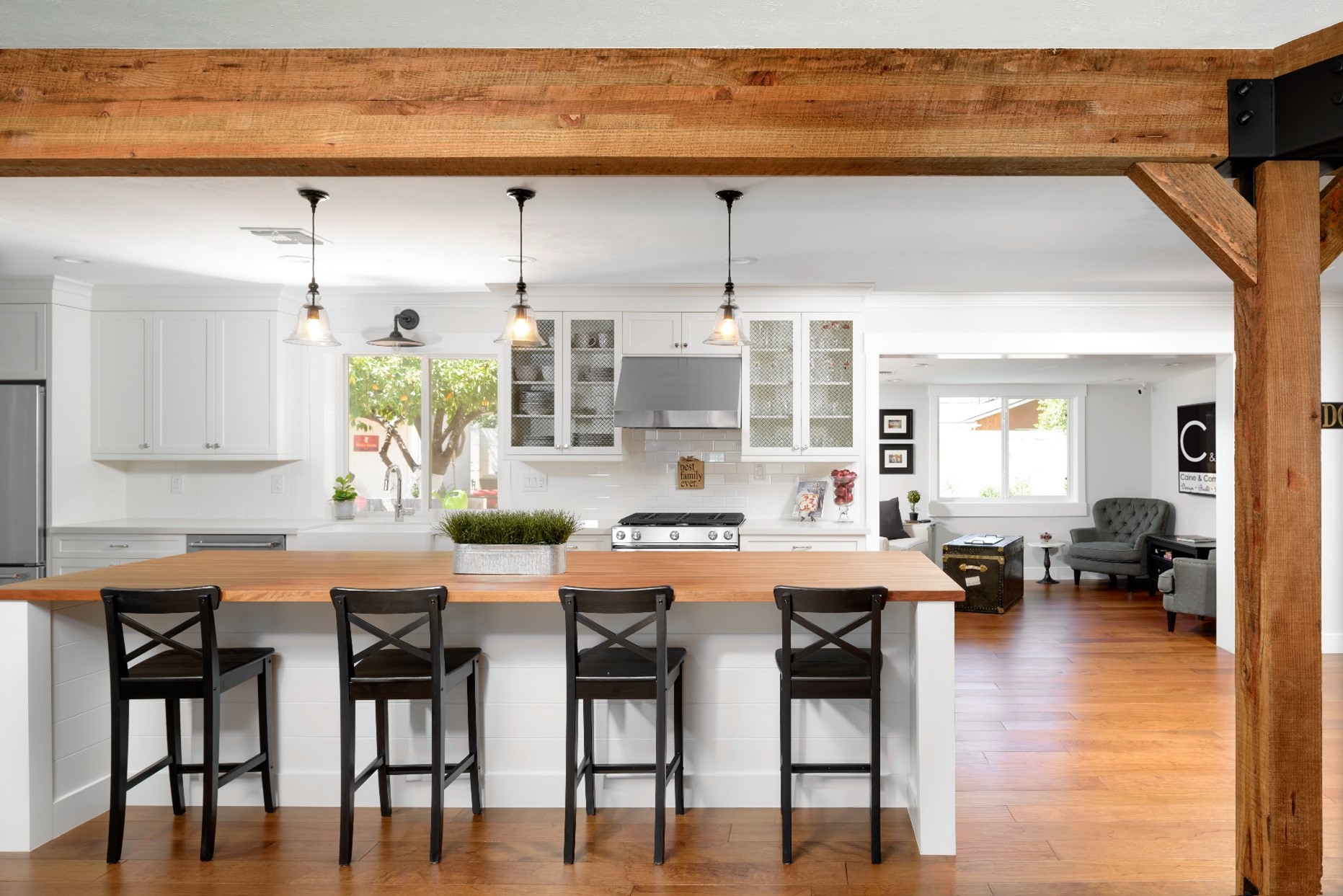 Wooden support beams and four bar stool chairs at the kitchen