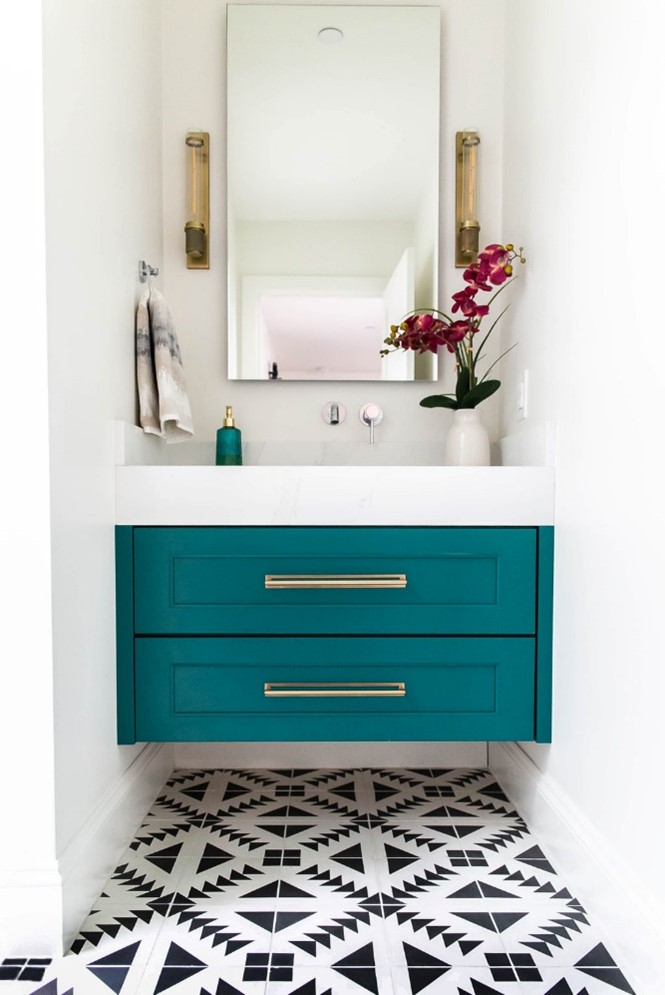 Bathroom with teal cabinetry and single vanity